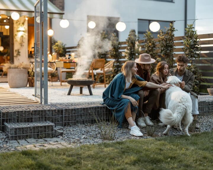 Un groupe d'amis sur la terrasse d'un jardin, à titre d'exemple d'espace extérieur aménagé.