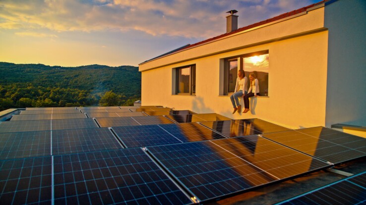 Photovoltaikanlage auf dem Dach eines Einfamilienhauses bei Sonnenuntergang.