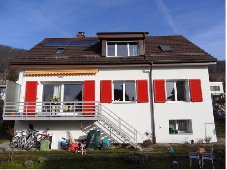 Rénovation énergétique : maison individuelle équipée d'une installation solaire thermique sur le toit, après une modernisation réussie