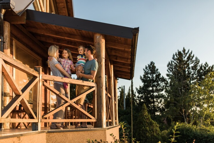 Une famille se détend sur la terrasse d'une maison de vacances.