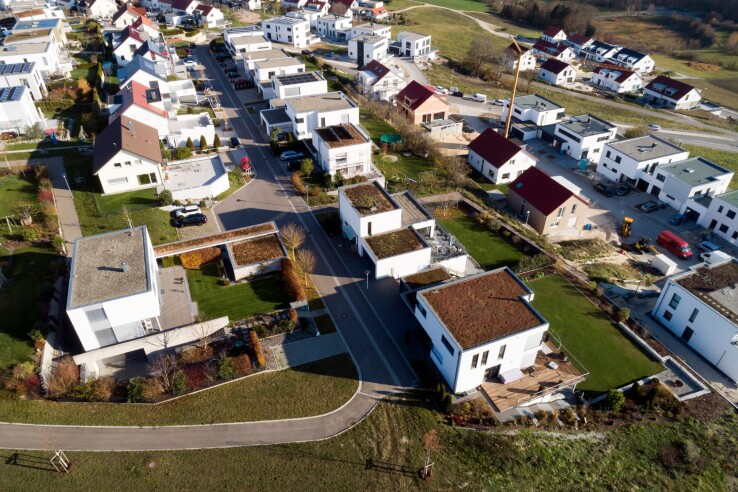 Comparaison de différents types de logements : maison individuelle, maison mitoyenne et immeuble collectif dans un quartier résidentiel.