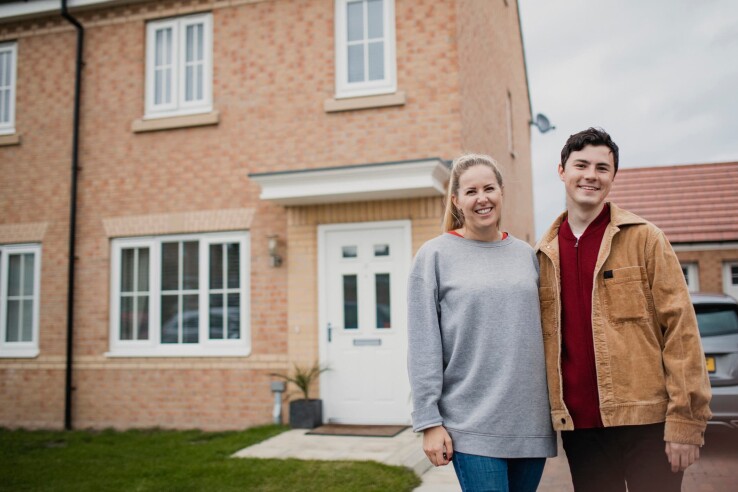 Une femme et un jeune homme se tiennent devant une maison individuelle, image symbolique illustrant le test sur les types de maisons.