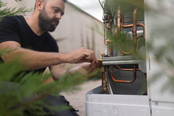 Un homme concentré installe une pompe à chaleur