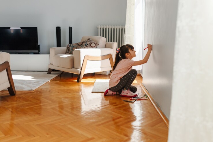 Un enfant peint un mur dans un appartement en location : un exemple de dégât locatif pouvant relever d’une usure excessive.