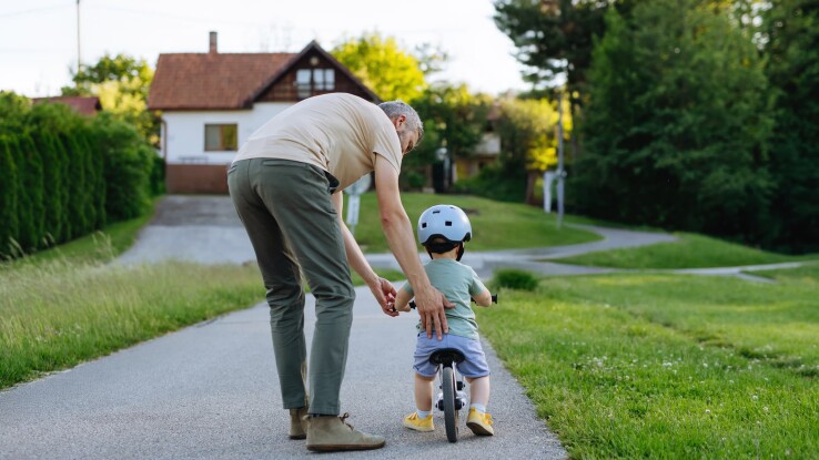 Vater und Sohn fahren mit dem Fahrrad auf einer Privatstrasse