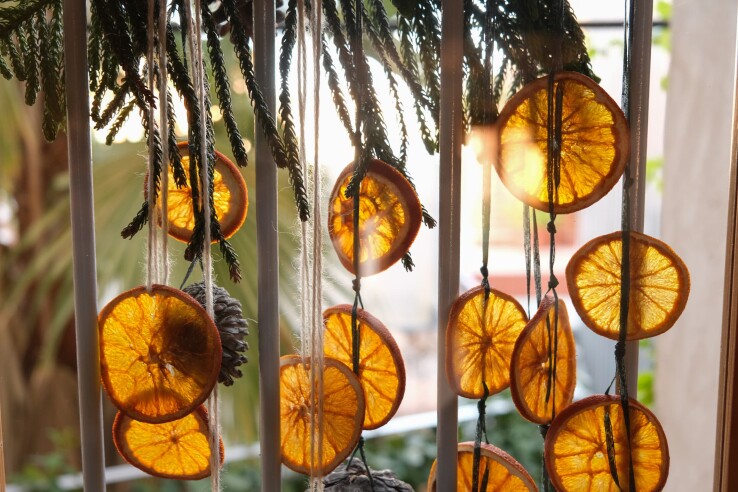 Fenêtre de l’Avent décorée de rondelles d’orange séchées et de branches de sapin.
