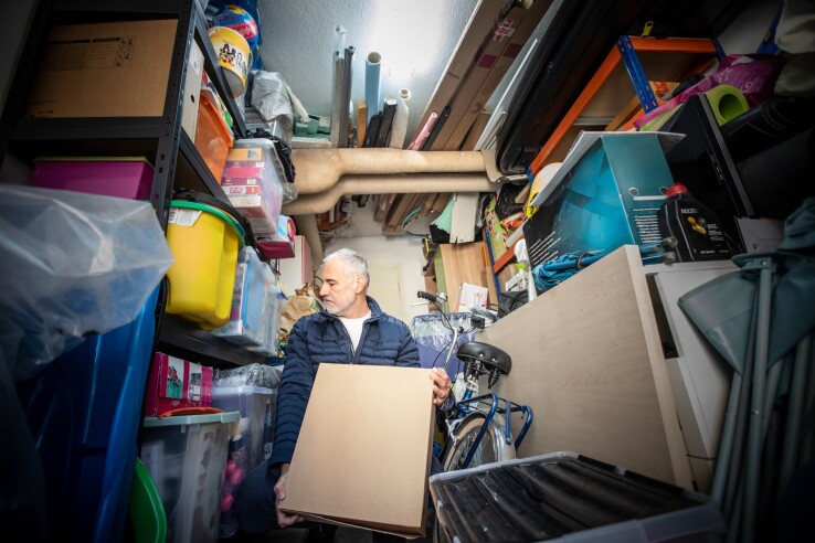 Un homme range une cave encombrée et trie les objets pour mettre de l'ordre et gagner de la place.