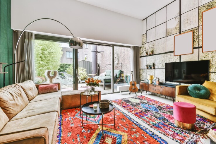 Salon de style maximaliste, avec un tapis coloré, des meubles qui ne passent pas inaperçus et des accessoires décoratifs.
