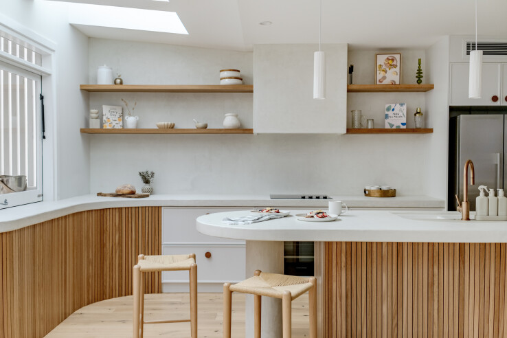 Une cuisine moderne aux formes arrondies, aux couleurs chaudes et dotée d'appareils intelligents, illustrant les tendances de la cuisine en 2026.