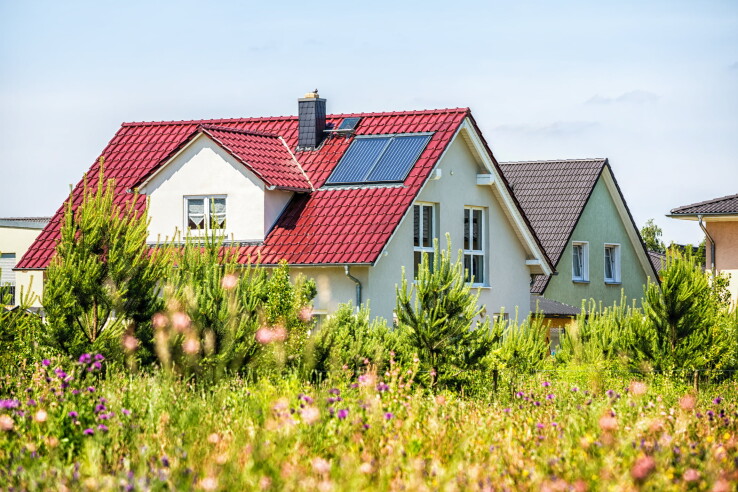 Une maison individuelle équipée d'un système solaire et d'un jardin, illustrant l'évaluation d'un bien immobilier en Suisse.