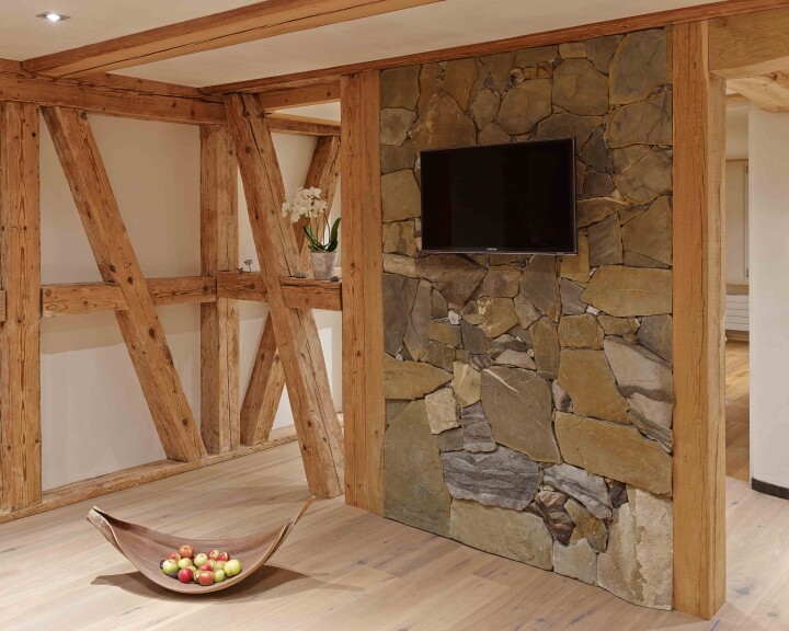 Reportage architectural à propos de la maison à colombages à Herbligen : une salle de bains en bois, en pierre et en terre crue