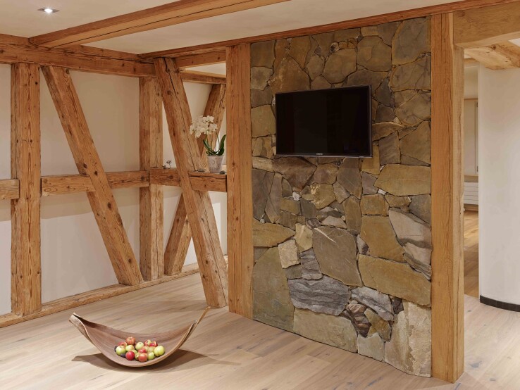 Reportage architectural à propos de la maison à colombages à Herbligen : une salle de bains en bois, en pierre et en terre crue