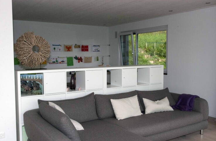 Reportage architectural Nussbaumen Feng Shui : derrière le canapé se trouve une commode blanche