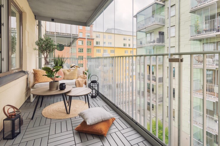 Kleiner Stadtbalkon mit Klickfliesen, Sitzbereich, Pflanzen und moderner Balkongestaltung.
