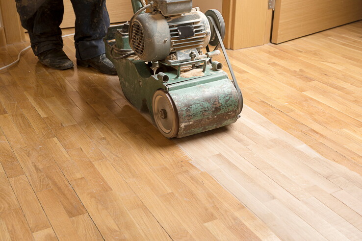 Une ponceuse à parquet ponce un parquet pendant des travaux de rénovation.