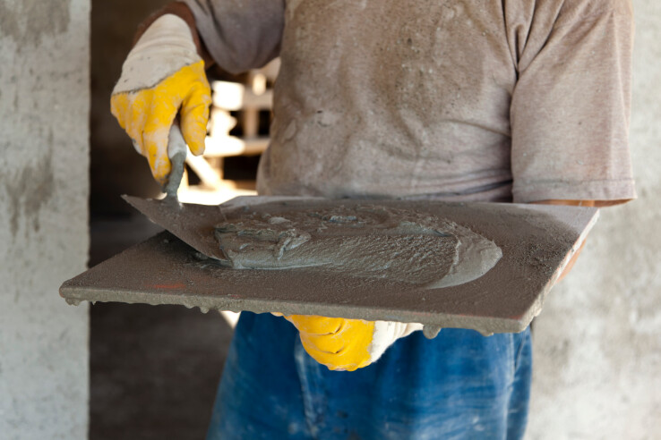 Du béton à faire soi-même : un bricoleur étale le béton sur la dalle
