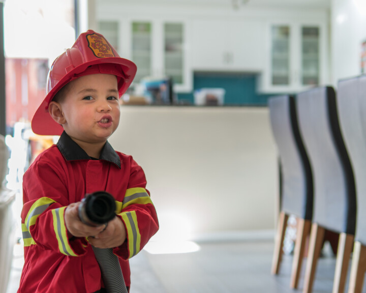 Un petit enfant joue aux pompiers et incarne la prévention des incendies et la manière de manipuler le feu en toute sécurité.