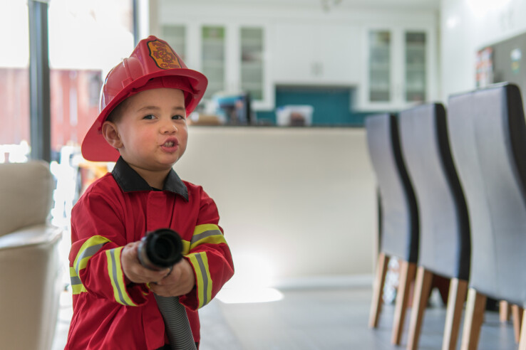 Un petit enfant joue aux pompiers et incarne la prévention des incendies et la manière de manipuler le feu en toute sécurité.