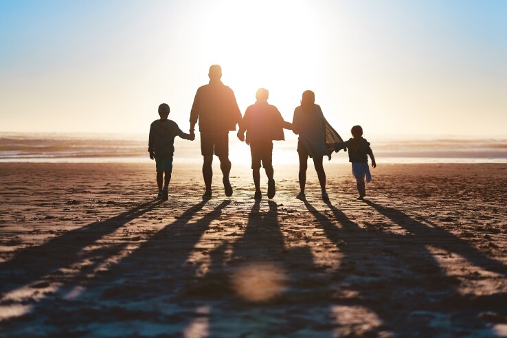 Une famille recomposée avec des enfants à la plage, pour illustrer le droit successoral des beaux-enfants en Suisse.
