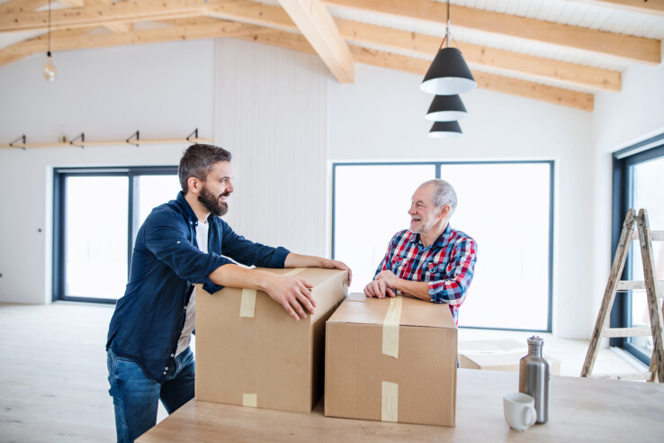Un père et son fils emménageant dans leur propre maison – image symbolique de l'avance sur héritage en Suisse