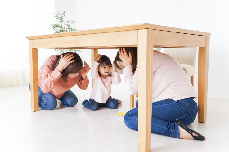 Une famille se réfugie sous une table solide pour se protéger d'un tremblement de terre.