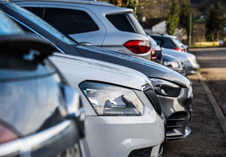 Plusieurs voitures sont garées sur un parking privé, illustrant ainsi le problème du stationnement illicite sur une propriété privée.