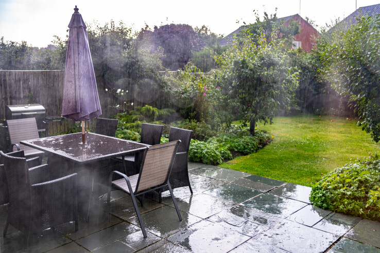 L'eau de pluie s'infiltre dans un terrain aménagé en espace vert, illustrant ainsi un système de drainage durable des terrains.
