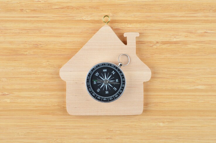 Une boussole sur une maison en bois – symbole permettant de déterminer l'orientation optimale de la maison.