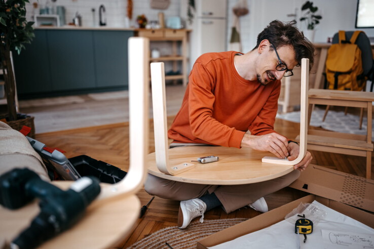 Une personne monte une table dans son appartement – l'assurance habitation couvre les meubles et les biens mobiliers en cas de dommages ou de vol.