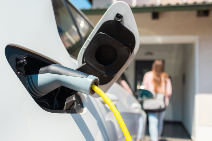 La voiture électrique se recharge à domicile grâce à une borne de recharge murale et un câble de recharge, sur le parking privé.