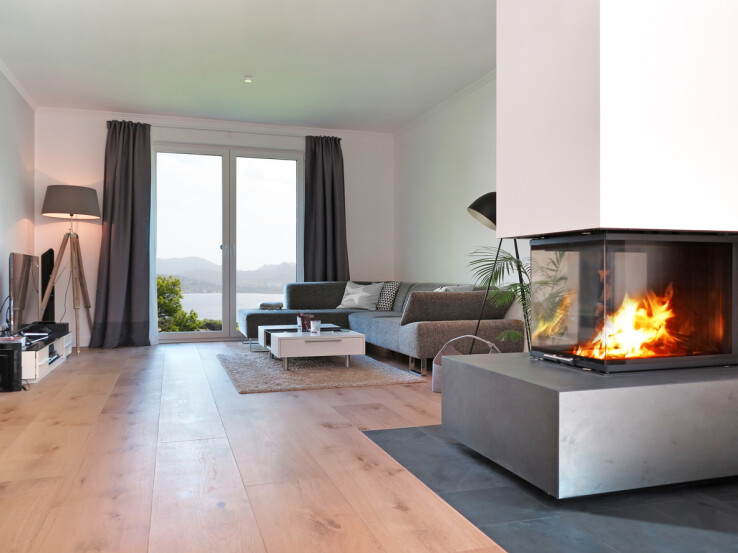 Une cheminée moderne dans un salon avec foyer apparent : un chauffage au bois efficace pour un confort accru et une chaleur supplémentaire.