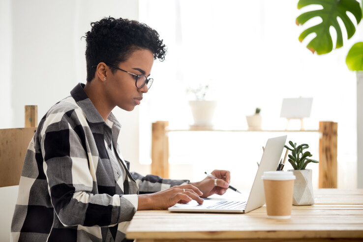 Une personne devant son ordinateur portable symbolise la recherche d'un prêt immobilier en ligne et la comparaison des offres de financement