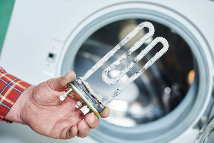 La résistance entartrée d'une machine à laver, un exemple qui montre l'importance de détartrer régulièrement les appareils ménagers.