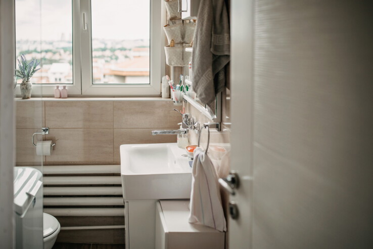 Petite salle de bains lumineuse avec lavabo, fenêtre et aménagement peu encombrant