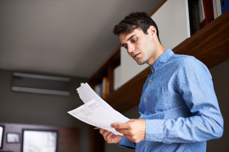 Un homme vérifie des documents. Image illustrative sur le thème de la résiliation d'un bail.