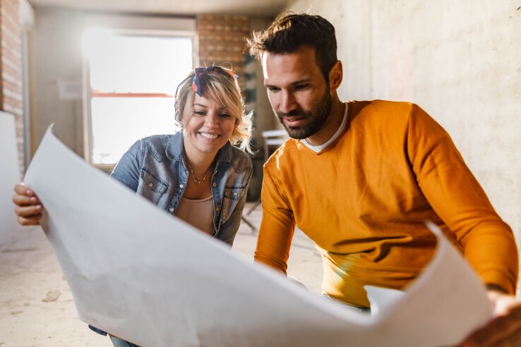 Un couple construit une maison d'habitation selon des méthodes de construction à haute durabilité et dotée d'une enveloppe du bâtiment économe en énergie.