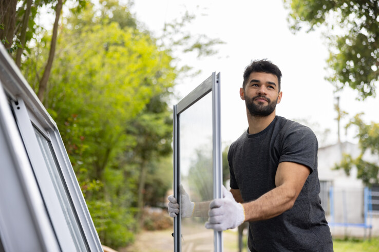 Un professionnel remplace une fenêtre dans une maison d'habitation.