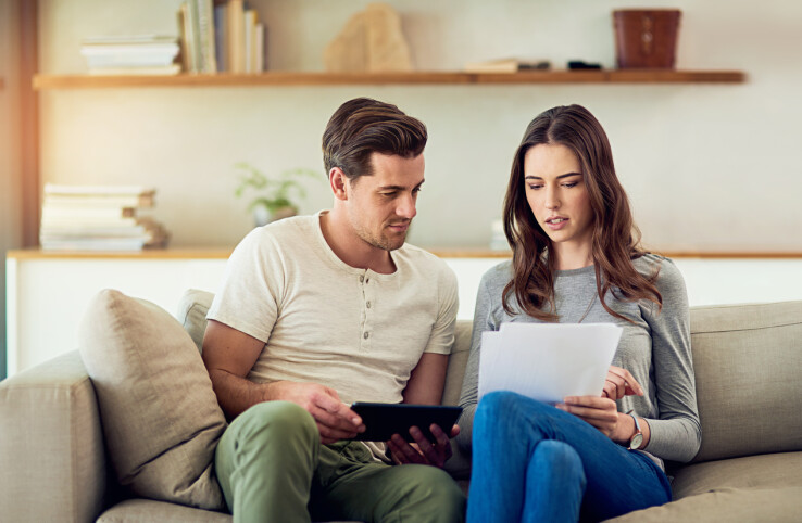 Un couple compare les offres de prêt immobilier et les documents de financement en vue de l'achat d'un logement.