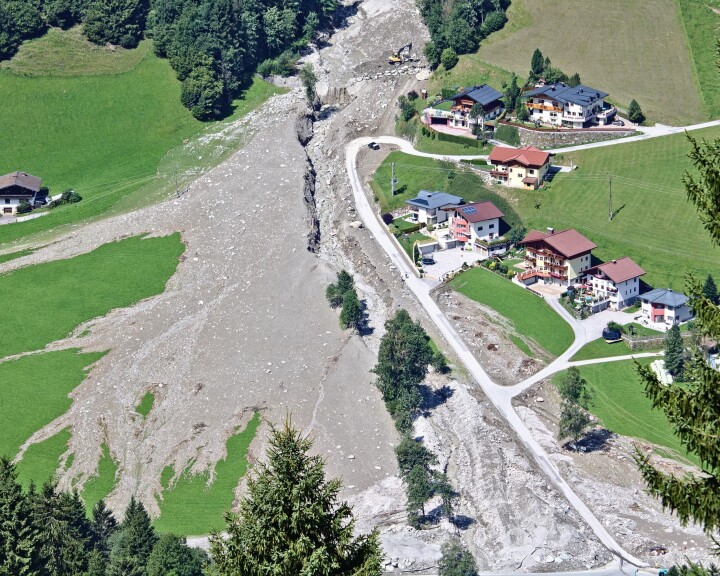 Un glissement de terrain dans un village de montagne, illustrant les risques naturels et la protection des bâtiments en Suisse.