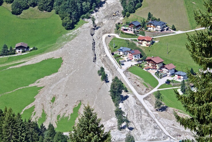 Un glissement de terrain dans un village de montagne, illustrant les risques naturels et la protection des bâtiments en Suisse.