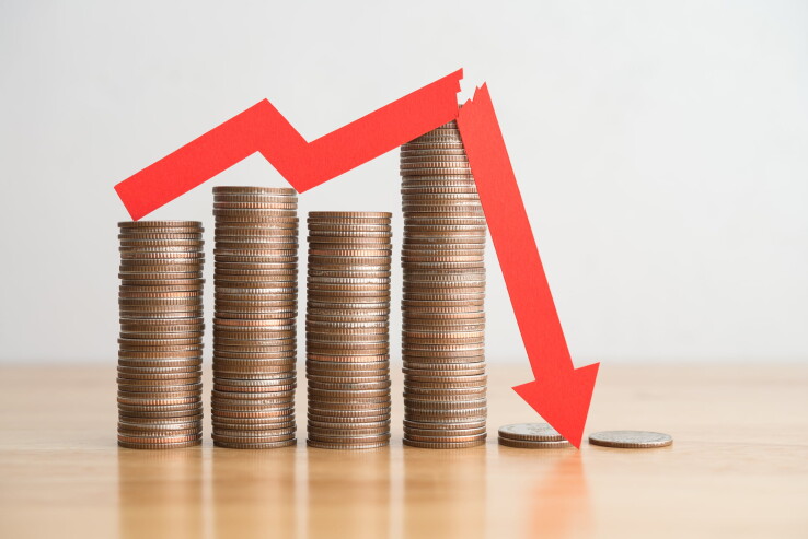 Des pièces empilées, accompagnées d'une flèche rouge pointant vers le bas, symbolisant la baisse des taux d'intérêt et le taux directeur de la BNS.