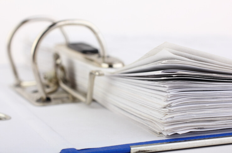 Un classeur à anneaux contenant des documents, symbolisant le règlement intérieur de la copropriété.