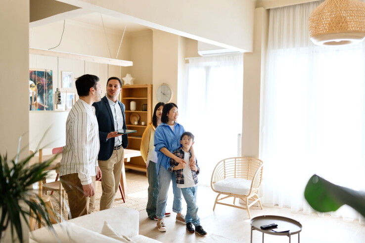 Familie besichtigt mit einem Immobilienberater eine Eigentumswohnung als Symbolbild für den Wohnungsverkauf.