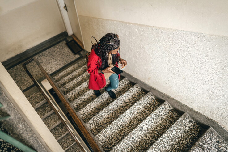 Une personne emprunte une cage d'escalier dans un immeuble collectif – les issues de secours doivent rester librement accessibles à tout moment.