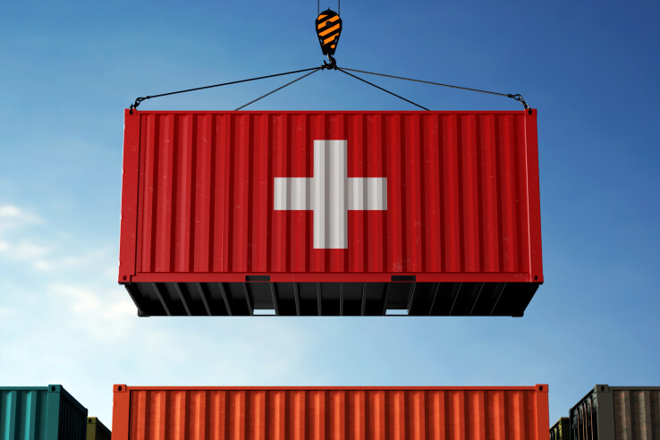 Des conteneurs arborant le drapeau suisse, symbolisant l'impact des droits de douane américains sur la Suisse.