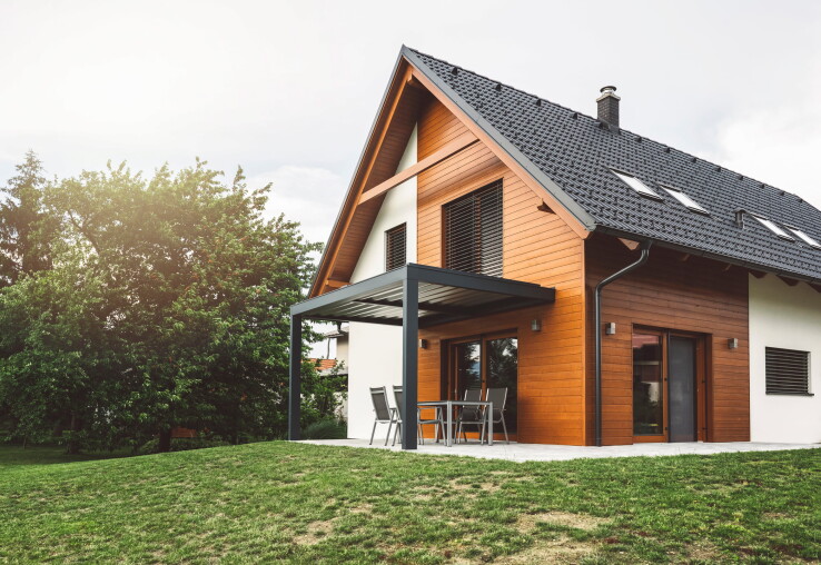 Maison individuelle moderne dotée d'une façade en bois et d'une terrasse couverte, servant d'exemple pour l'évaluation de la valeur vénale d'un bien immobilier.