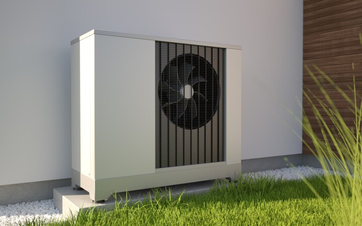 Pompe à chaleur air-eau installée sur le mur extérieur d'une maison individuelle.