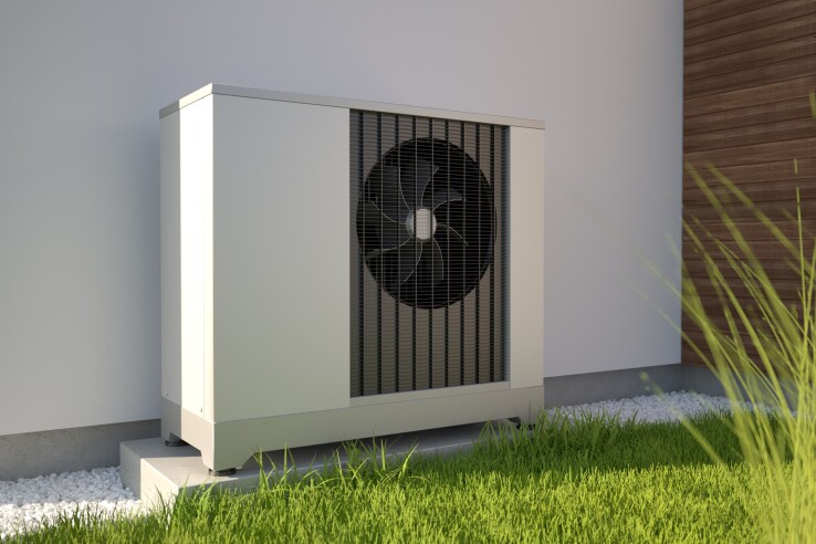 Pompe à chaleur air-eau installée sur le mur extérieur d'une maison individuelle.