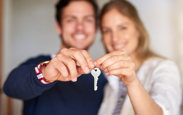 Un couple en possession des clés de leur maison après avoir acheté ensemble un bien immobilier en Suisse.