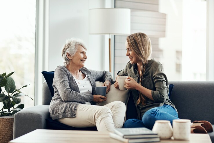 Mutter und Tochter besprechen auf dem Sofa die Übertragung von Wohneigentum in der Familie.